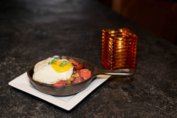 a skillet with eggs, meat and other fillings