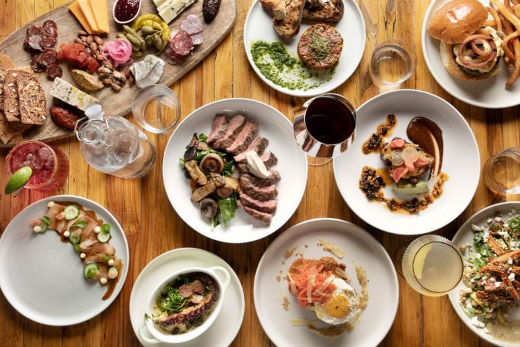 a spread of dishes on a light wood table