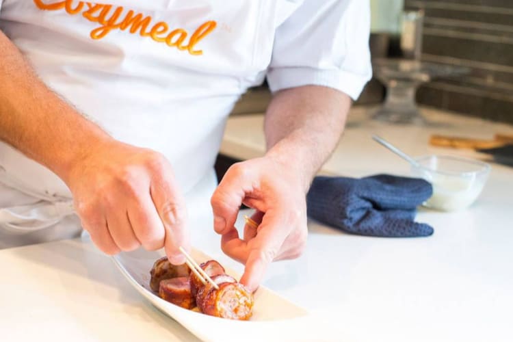 a chef preparing sausages for an appetizer