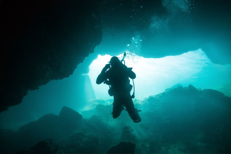 a SCUBA diver in an aquatic cave