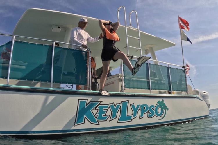 a woman jumping into the ocean from the Keylypso, a boat