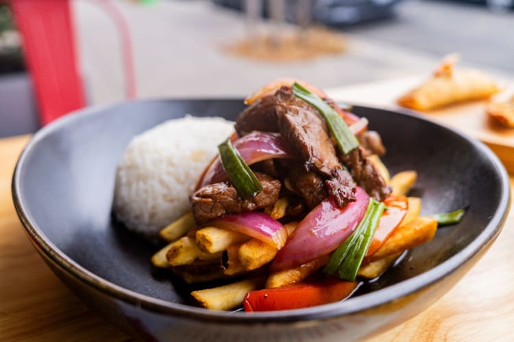 a plate of lomo saltado with white rice