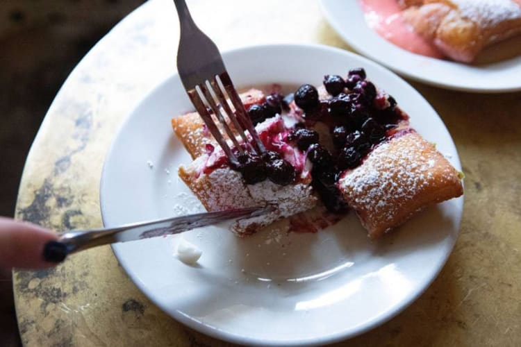 a diner cutting into a beignet