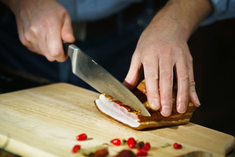 a chef cutting smoked meat