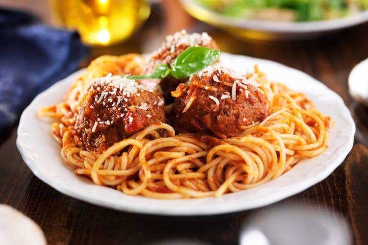 spaghetti with meatballs garnished with shaved Parmesan