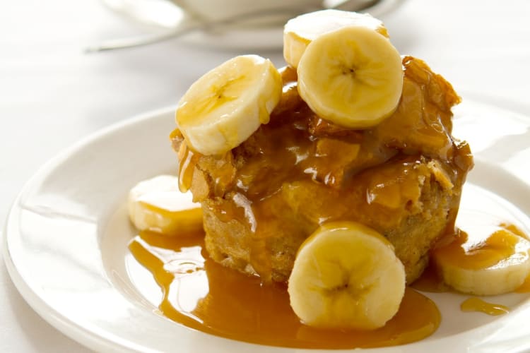 Banana bread pudding with caramel sauce and fresh banana slices