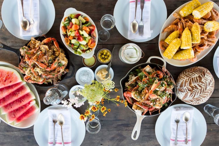 Seafood dishes and watermelon on a wooden table