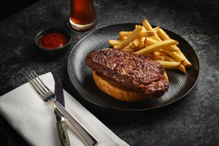 Steak and fries on a black plate