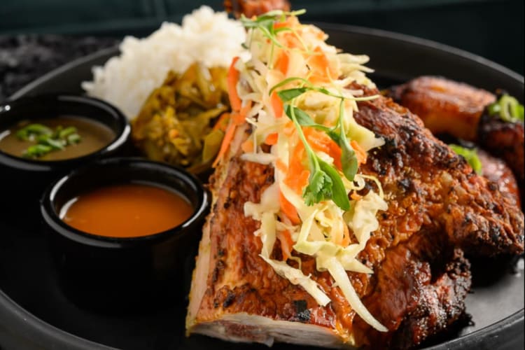 a plate with grilled chicken, rice and salad