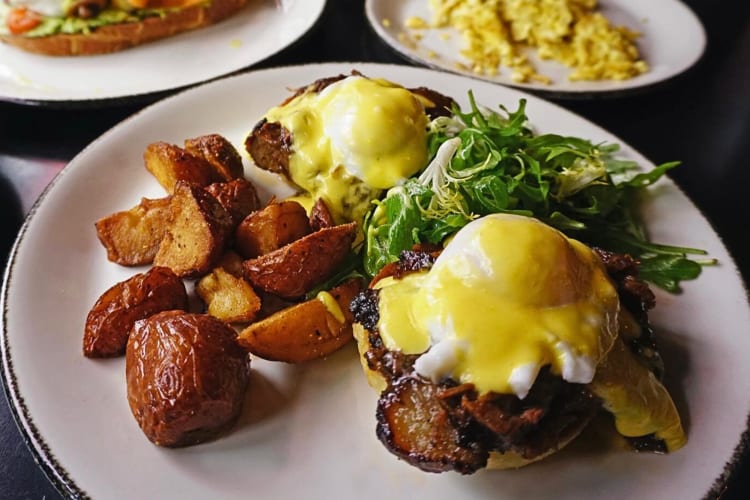 Breakfast meal with two eggs, potatoes, onions, bacon and buns from Rosebud Bar & Kitchen