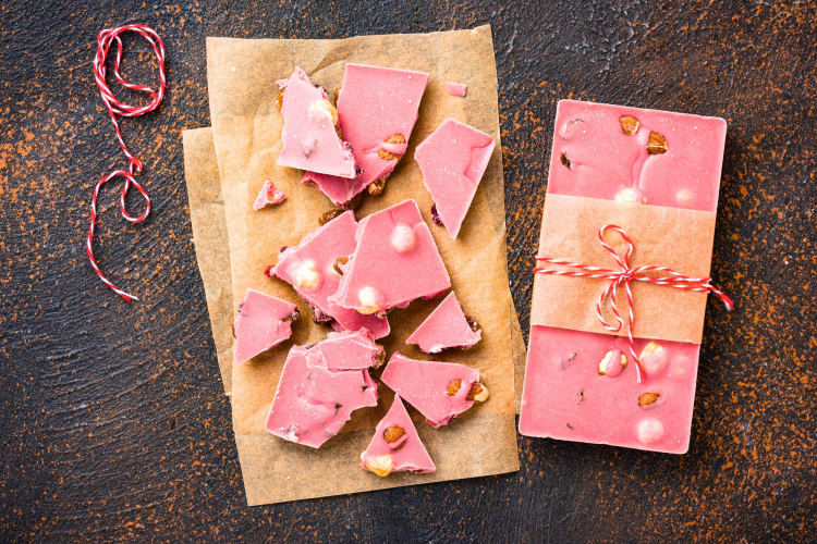 A bar of ruby chocolate wrapper in brown paper and a ribbon