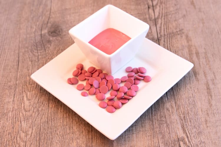 Melted ruby chocolate next to ruby chocolate chips