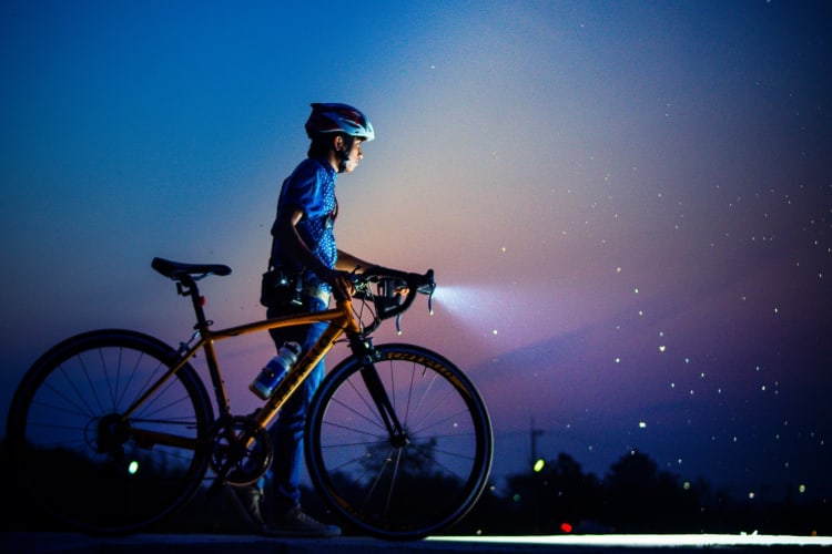 A person with a bike at night