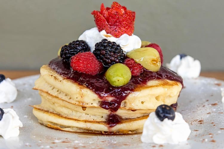 Pancakes topped with syrup, cream and berries from Sabrina