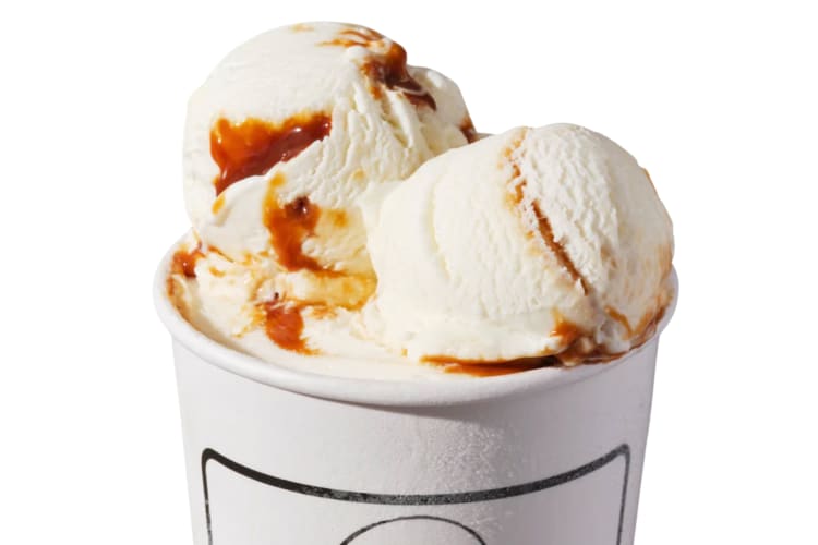 A tub of vanilla ice cream with caramel swirl