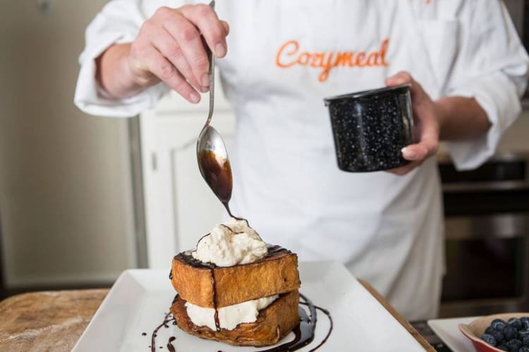 A chef pouring chocolate over French toast