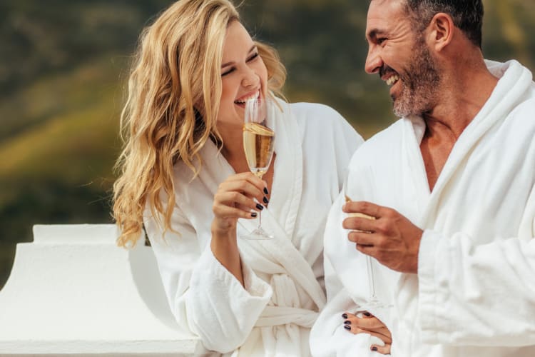 A couple in white bathrobes with champagne