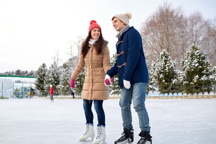 A couple ice skating outdoors