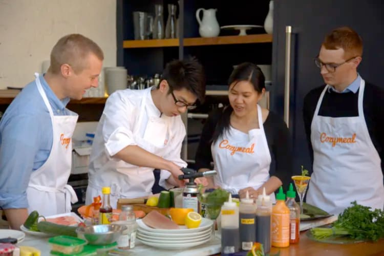 Three people taking a cooking class with a professional chef