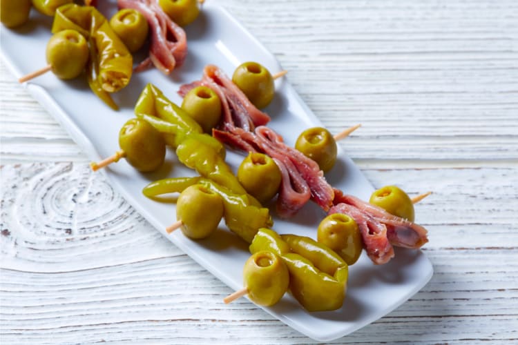 Combination of anchovies, olives and a gandia pepper speared on a skewer