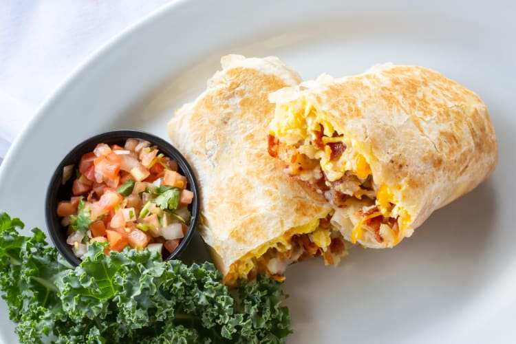 A breakfast burrito with a tomato salsa