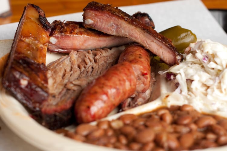 A selection of meat including brisket, a sausage and pork ribs