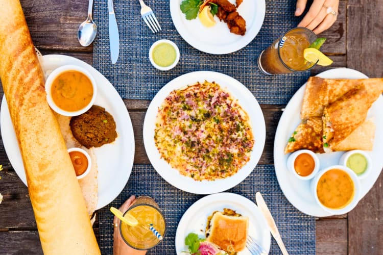 Dosa, other dishes and cocktails on a table