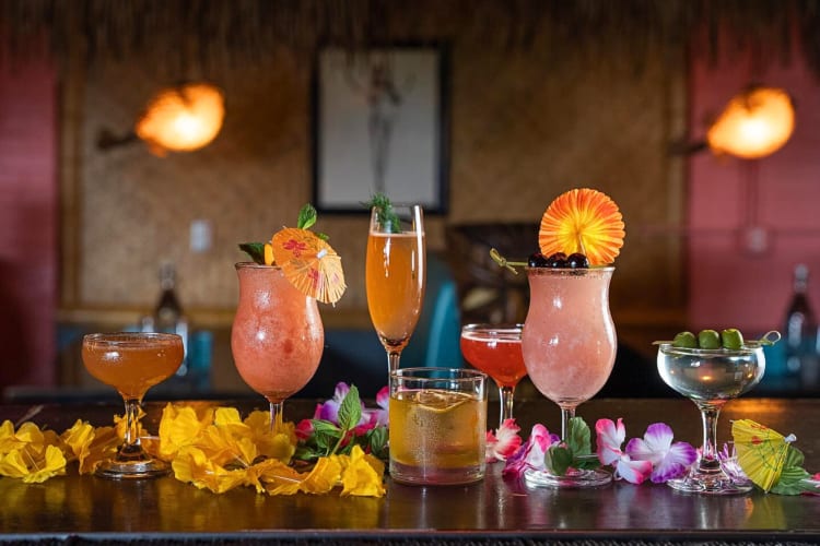 Seven drinks lined up in a row on a bar at Saturn Room