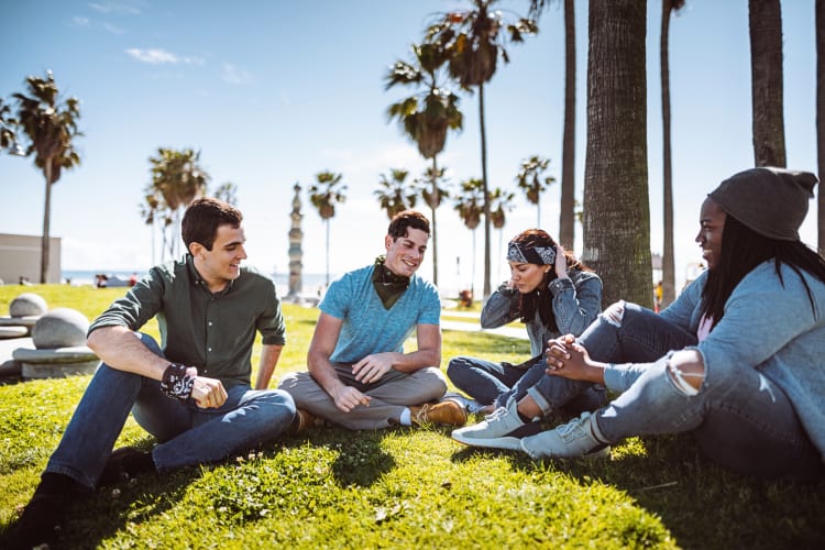 Four friends sitting on a patch of grass in Los Angeles