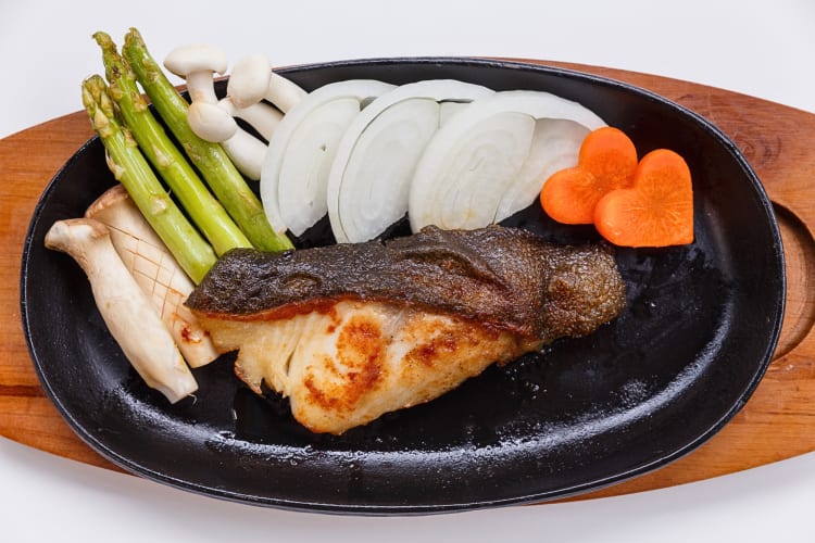 Sablefish steak with onions, carrots, mushrooms and asparagus