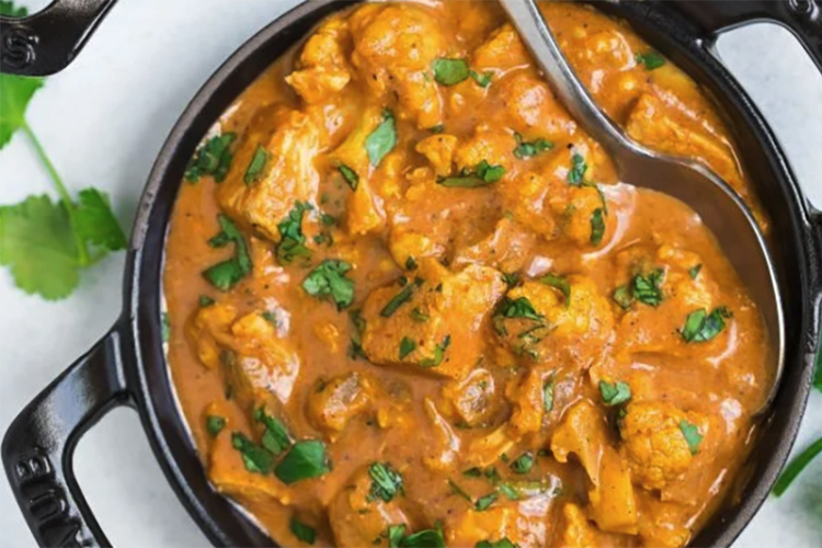 slow cooker butter chicken features a rich, creamy curry