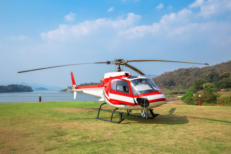 A helicopter on the grass next to the water