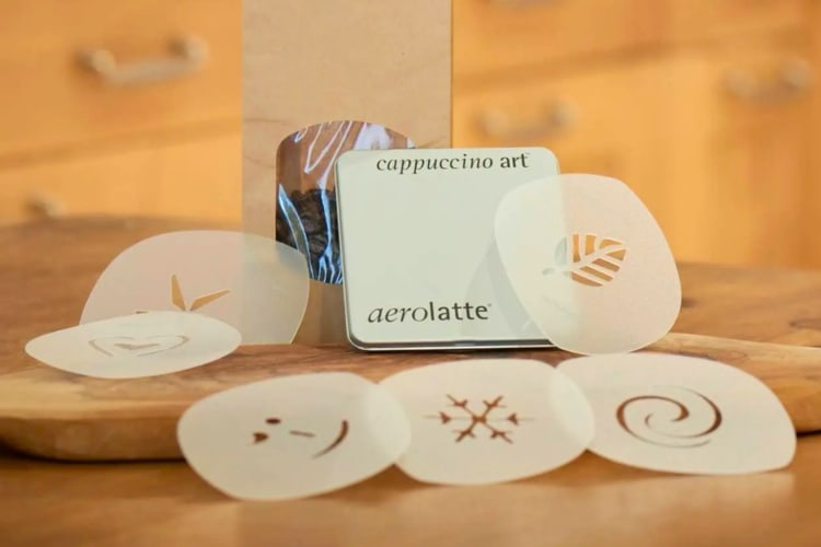 A set of coffee art stencils on a table next to a bag of coffee