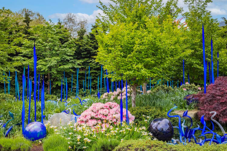 A colored glass display within a green garden 