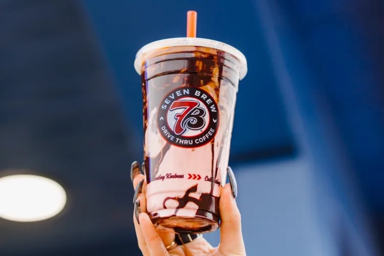 A person holding an iced coffee drink