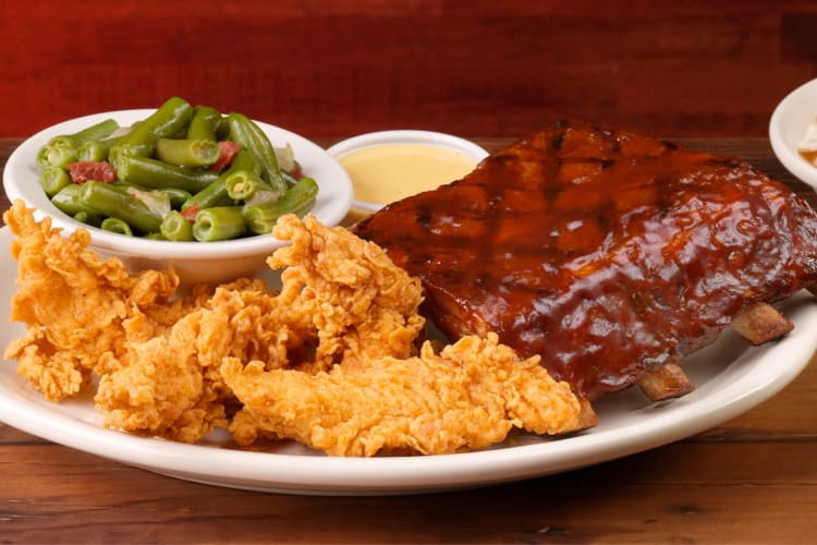 A plate of ribs, fried chicken and green beans