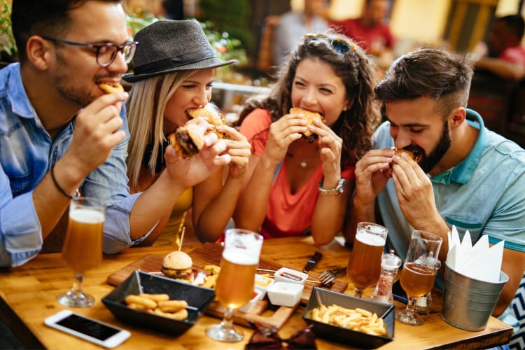 Four people eating at a table outdoors