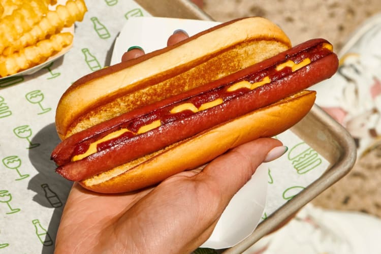 A person holding a hot dog