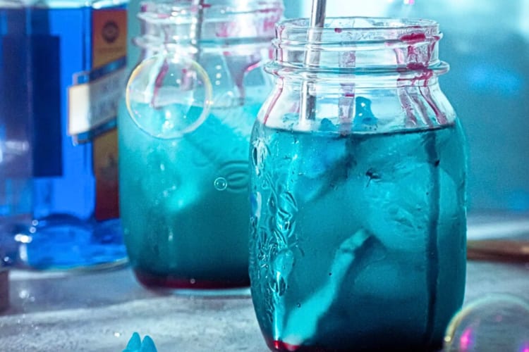 Two sharkbite cocktails in jars, one behind the other