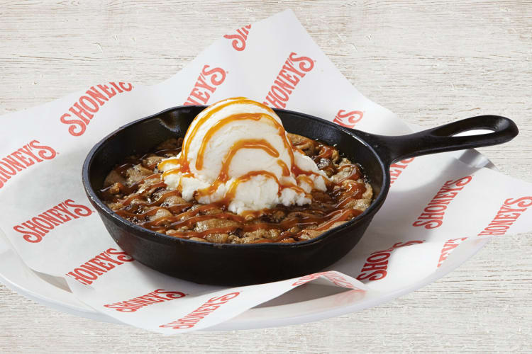 Skillet cookie topped with caramel sauce and vanilla ice cream, from Shoney’s