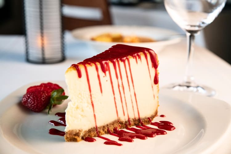 Slice of cheesecake with red syrup on top from Silver Fox