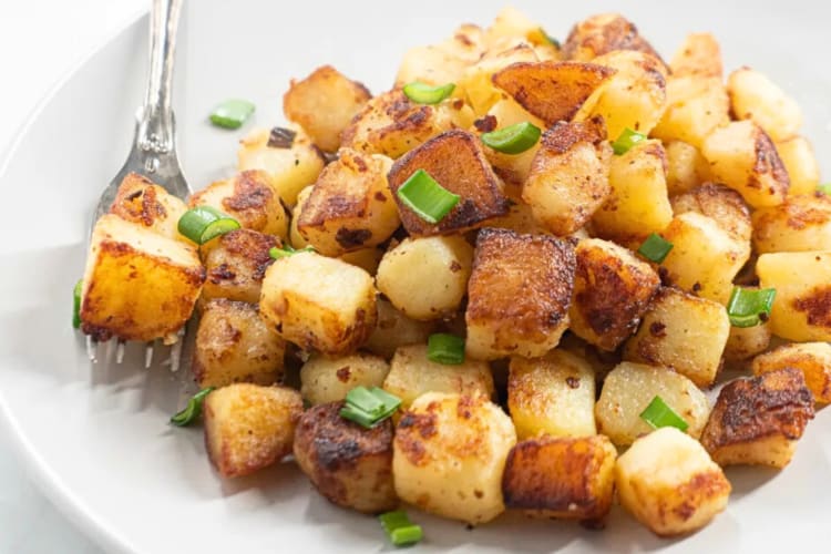 Skillet breakfast potatoes topped with chopped green onion
