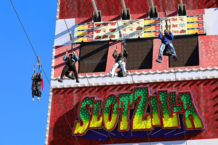 Four people riding ziplines at Slotzilla, a great place to go for team building activities in Las Vegas