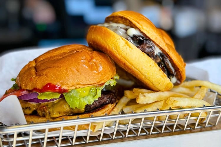 Side-view of two burgers and fries from Smashburger, a restaurant where kids eat free