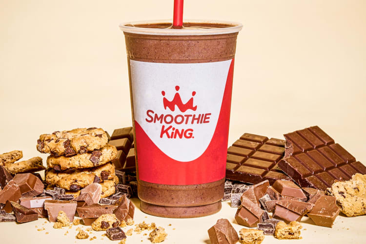 A chocolate smoothie next to chocolate chunks and cookies