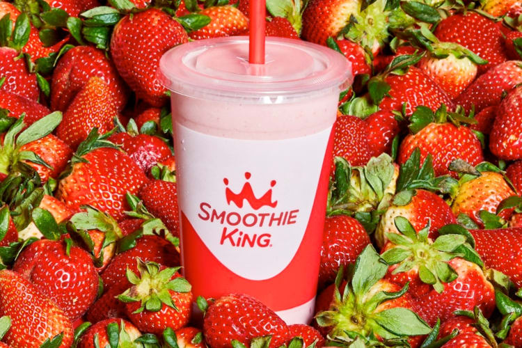 A strawberry smoothie and fresh strawberries
