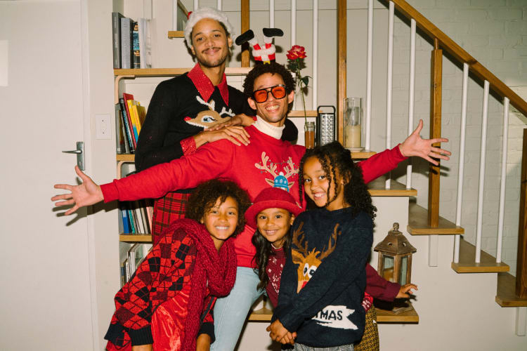 A family of five posing for a photo as a Christmas family tradition