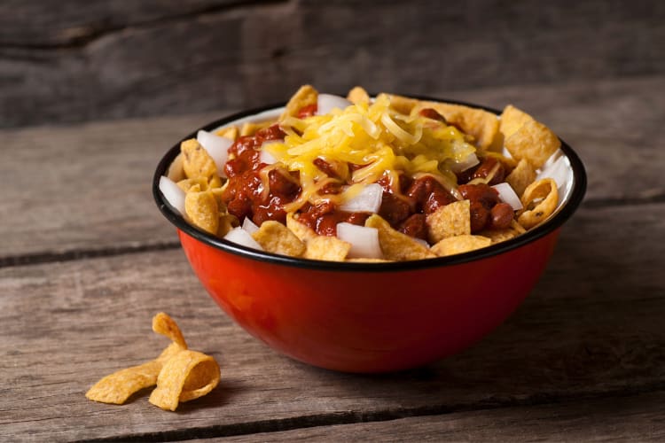 A bowl of Frito chips with chili and cheese