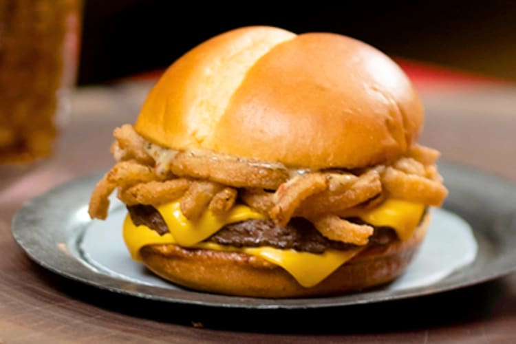 A cheeseburger with onion rings inside