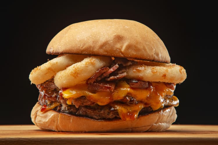 A cheeseburger with onion rings inside